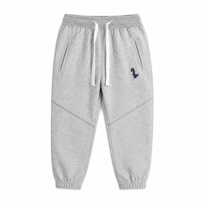 Front flat lay of the light gray kids cotton jogger pants with drawstring waist and dinosaur detail.
