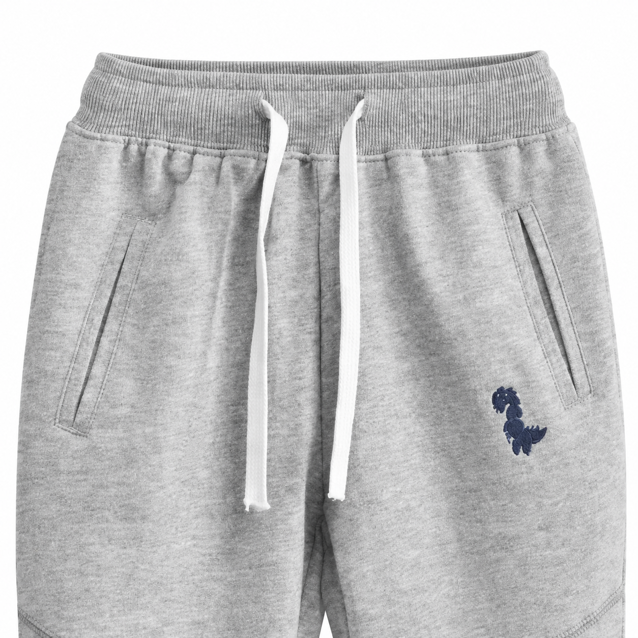 Close-up of the waistband, drawstring, pockets, and knee seam detail on the light gray kids joggers.
