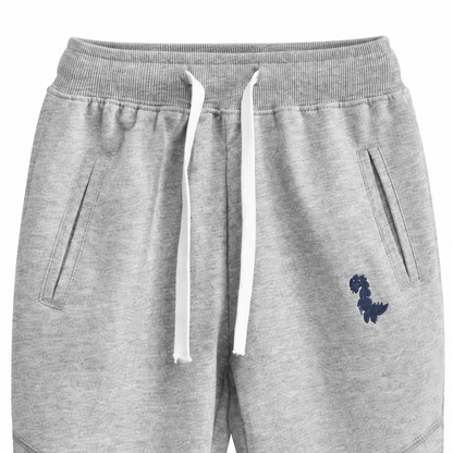 Close-up of the waistband, drawstring, pockets, and knee seam detail on the light gray kids joggers.