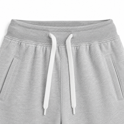 Close-up of the elastic waistband and contrast drawstring on the light gray kids jogger pants.