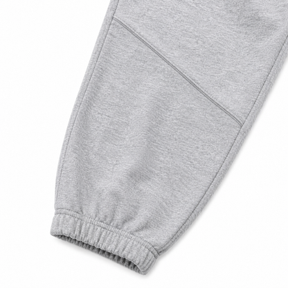 Close-up of the elastic cuff and knee seam detail on the light gray kids jogger pants.