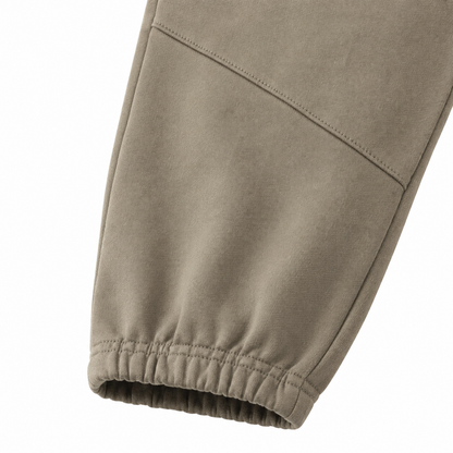 Close-up of the elastic cuff and knee seam detail on the taupe kids jogger pants.