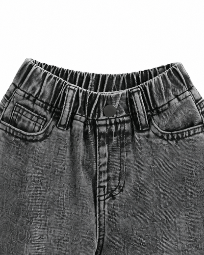Close-up of the elastic back waistband and denim stitching on the washed black jeans.