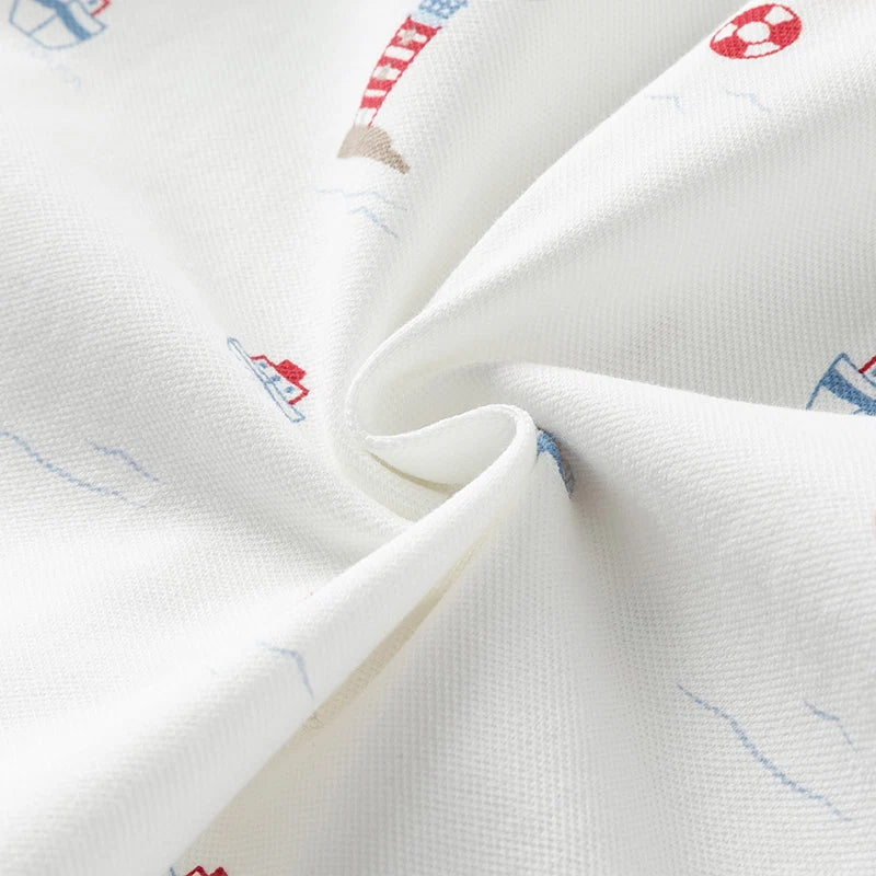 Close-up of the cotton-blend fabric texture and nautical print on the white boys polo shirt.