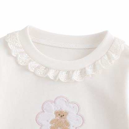 Close-up of the ruffle-trim crew neckline on the Ivory girls cotton long sleeve top.