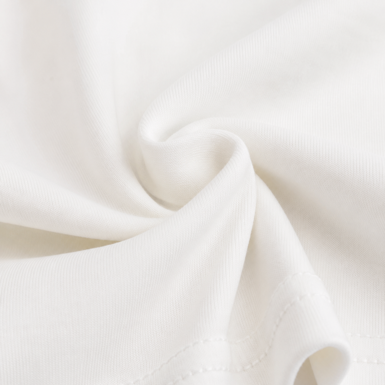 Close-up of the cotton fabric and construction detail on the Ivory girls long sleeve top.