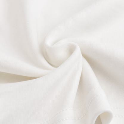 Close-up of the cotton fabric and construction detail on the Ivory girls long sleeve top.