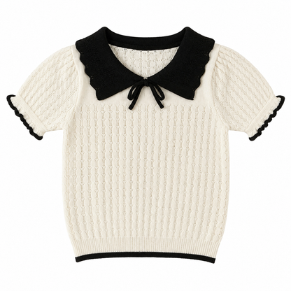 Front flat lay of an ivory girls knit top with a black bow collar and short sleeves.
