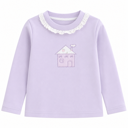 Front flat lay of the Lavender girls cotton long sleeve top with ruffle collar and storybook house embroidery on a white background.