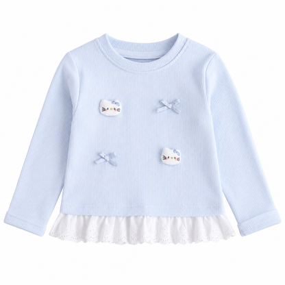 Front flat lay of a light blue girls cotton ruffle top with long sleeves and bow applique details on a white background.