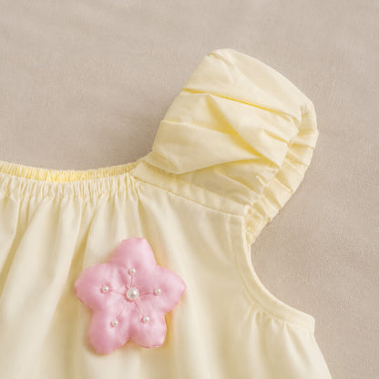 Close-up of the Lila Bloom Set pink flower applique and gathered shoulder detail.