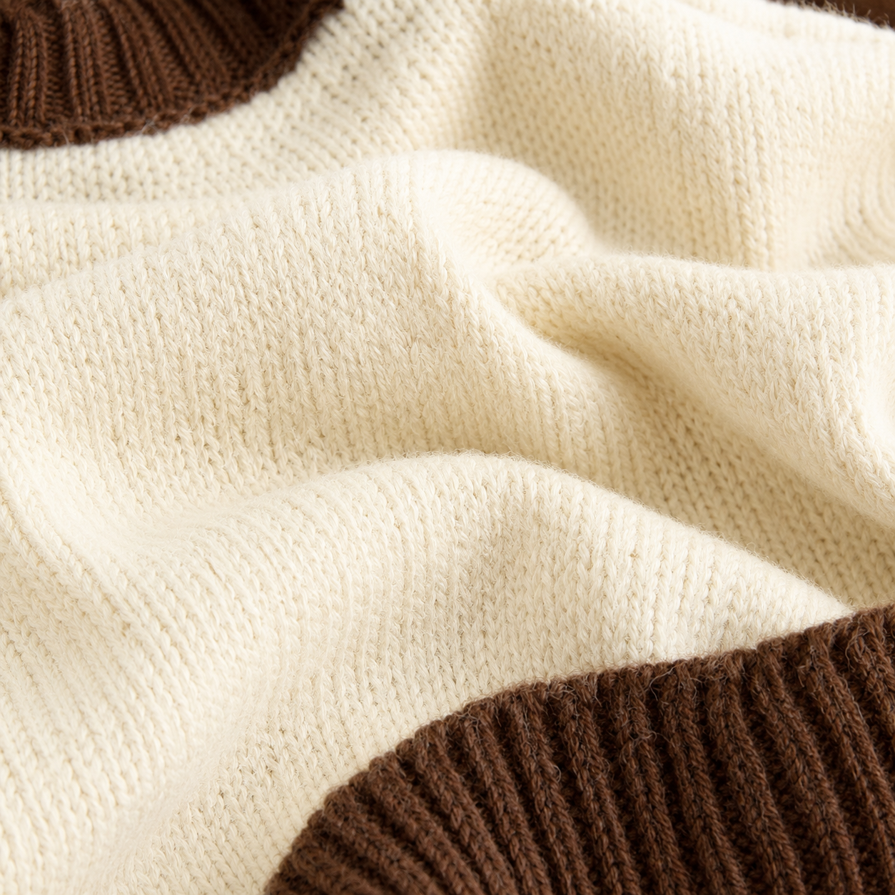 Close-up of the acrylic knit texture and ribbed hem on the ivory brown kids vest.