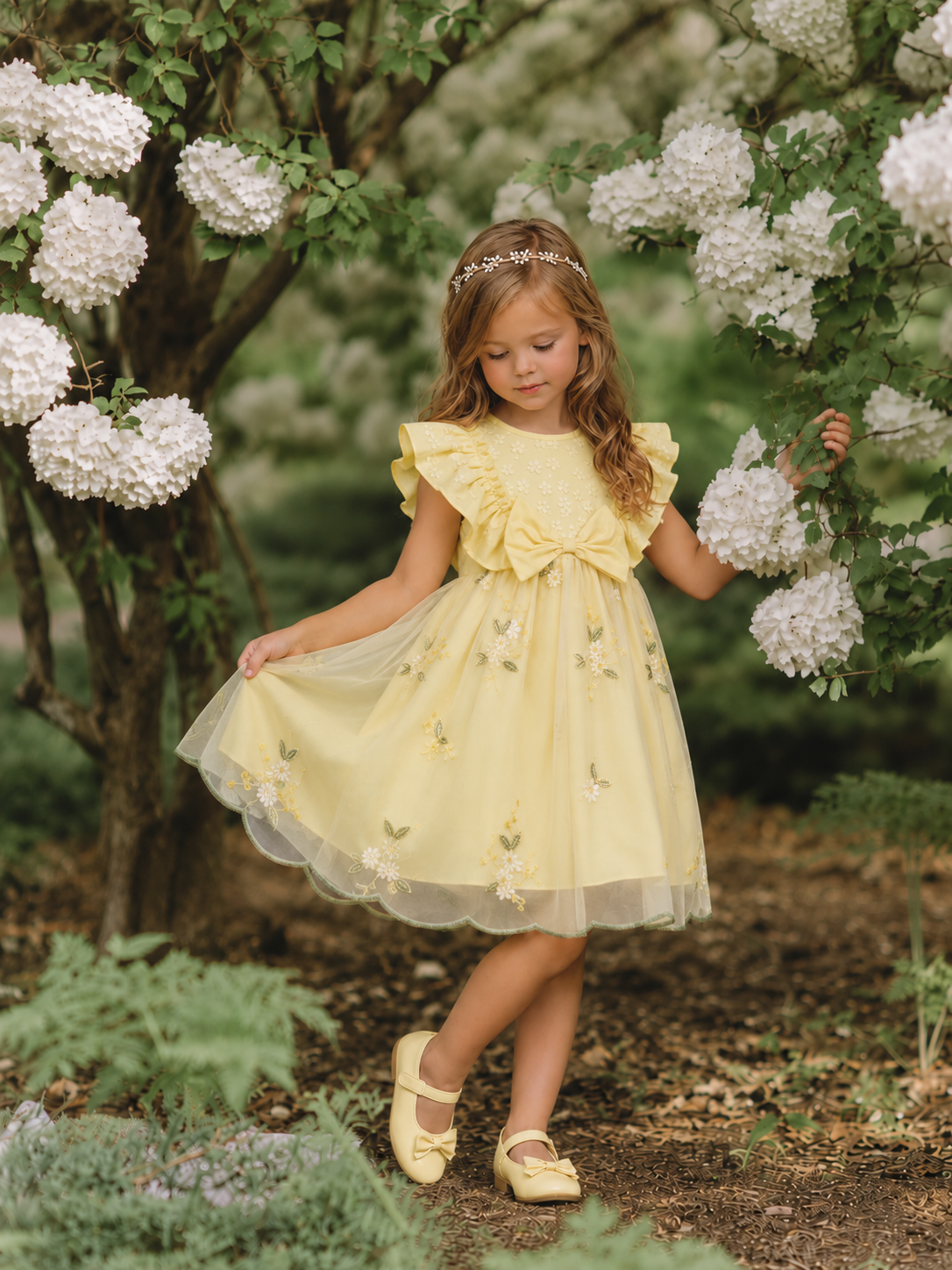 Girl wearing yellow Lottie Bloom tulle birthday dress