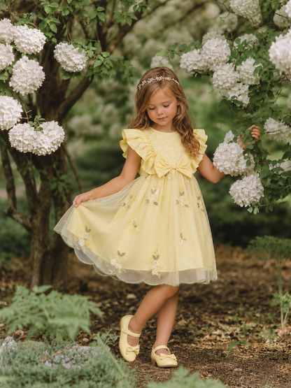 Girl wearing yellow Lottie Bloom tulle birthday dress