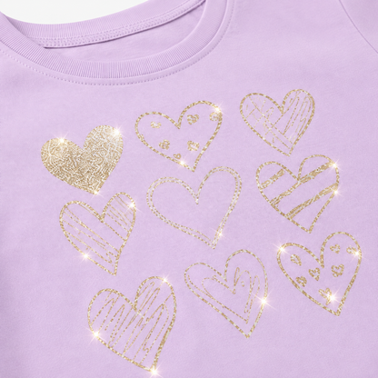 Close-up of the gold heart graphics on the lavender girls long sleeve tee.