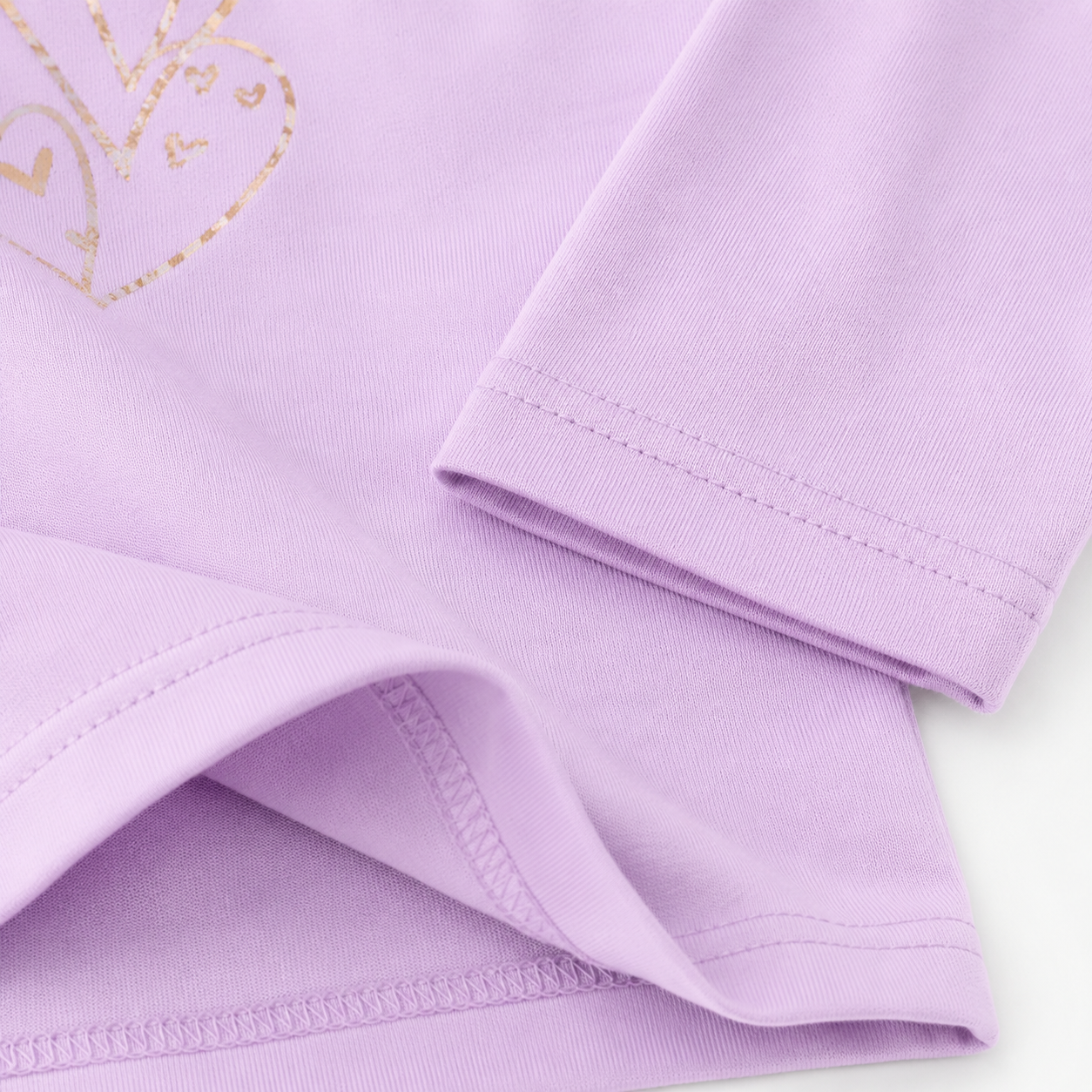 Close-up of the lavender cotton fabric, sleeve, and hem stitching.