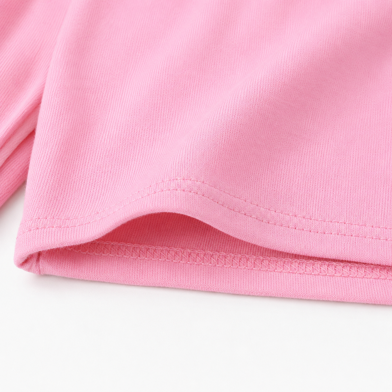 Close-up of the pink shorts hem and fabric detail.
