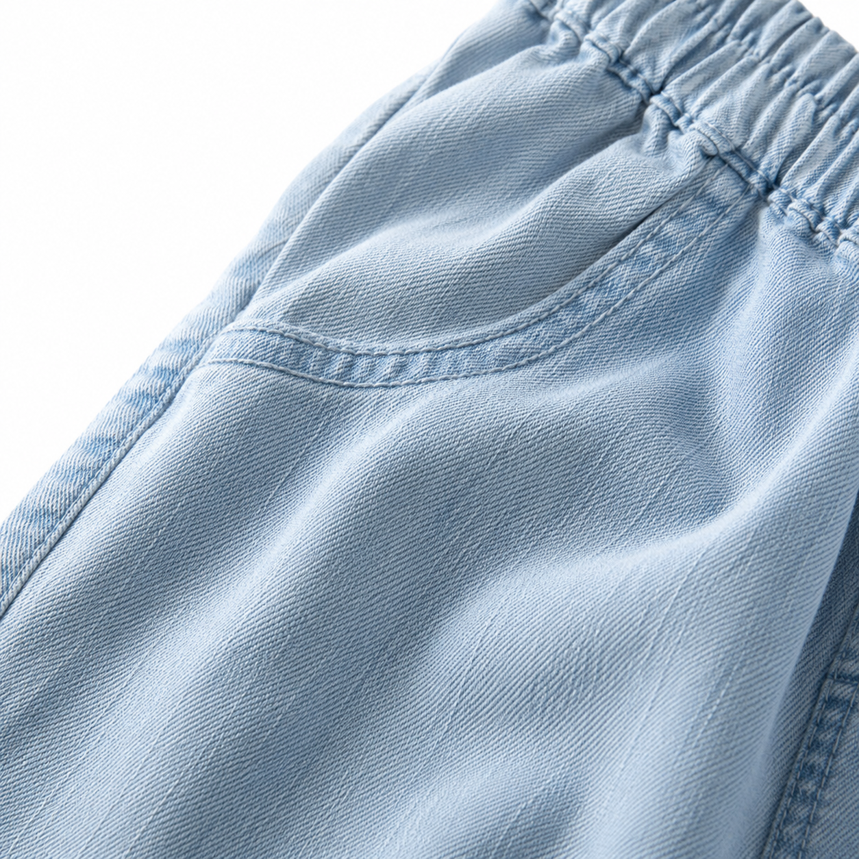 Close-up of the light blue denim fabric texture on the girls cropped jeans.