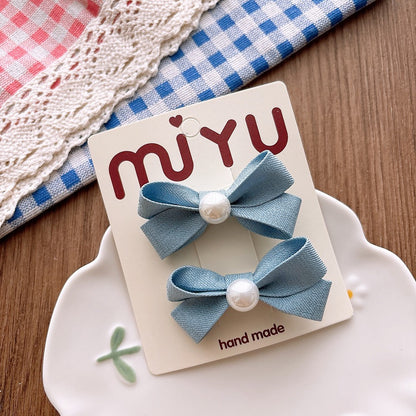 Meadow Pearl Bow Clip Set with soft blue bow hair clips and pearl details.
