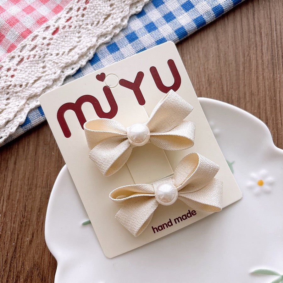 Meadow Pearl Bow Clip Set with ivory bow hair clips and pearl center details.