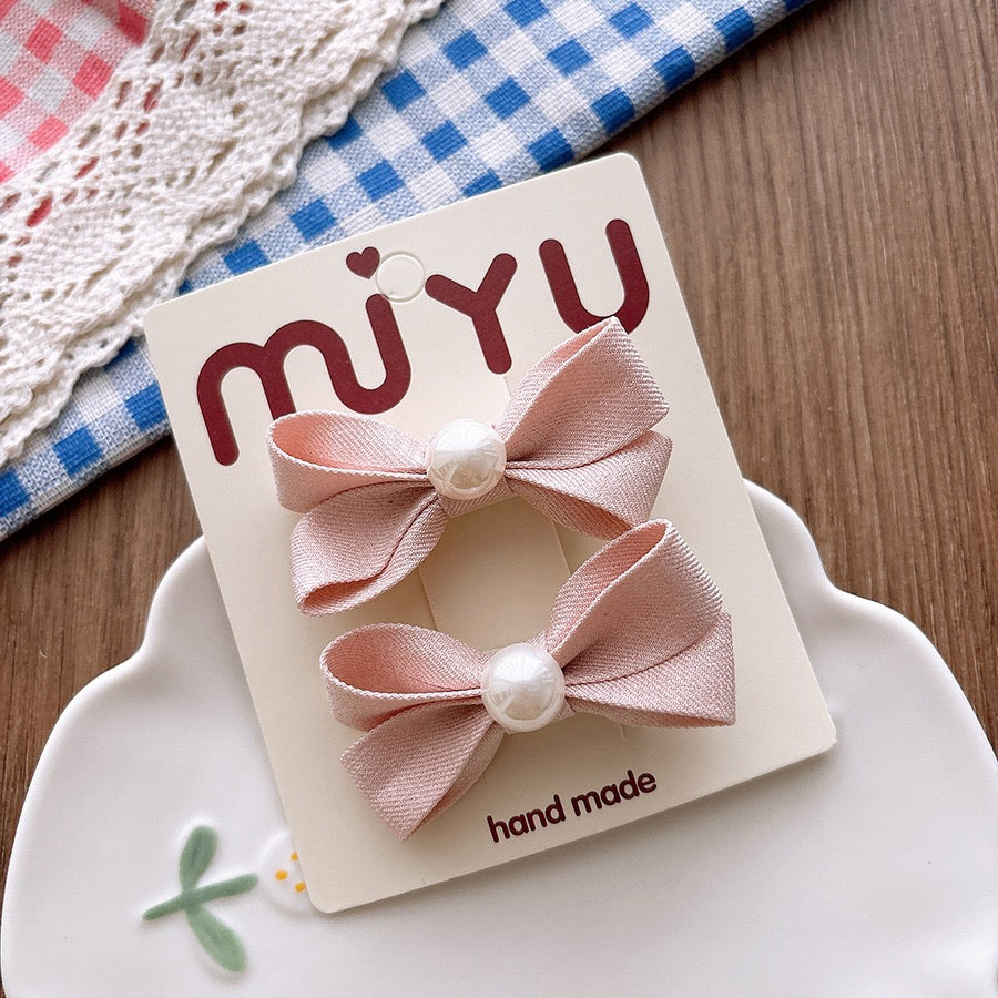 Meadow Pearl Bow Clip Set with soft pink bow hair clips and pearl centers.