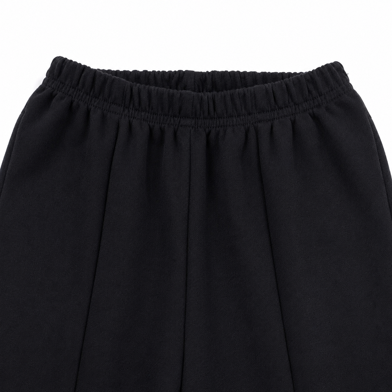 Close-up of the front waist and vertical seam detail on the black flare pants.