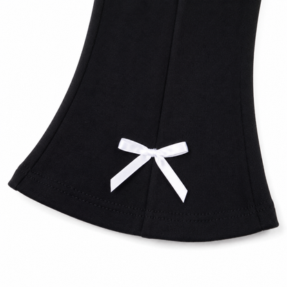Close-up of the white bow detail at the flared pant hem.