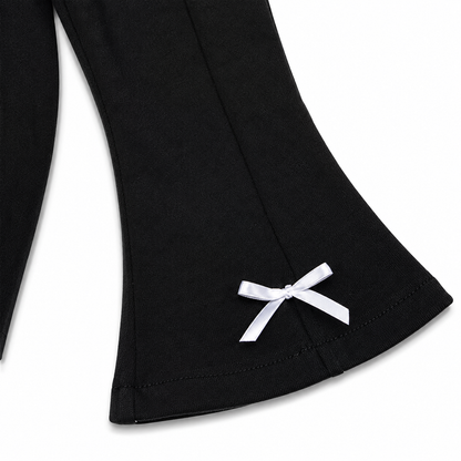 Close-up of the flared leg shape and hem detail on the black girls pants.