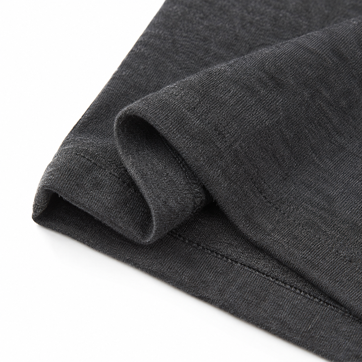 Close-up of the hem stitching and cotton fabric on the charcoal long sleeve kids shirt.