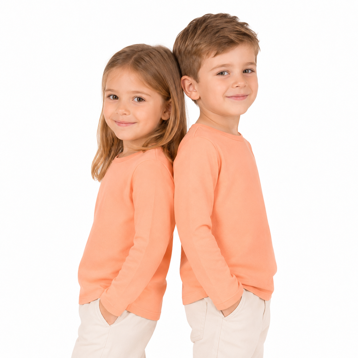Two child models wearing the peach unisex kids long sleeve cotton tee.