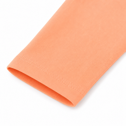 Close-up of the sleeve and cuff on the peach cotton long sleeve shirt for kids.