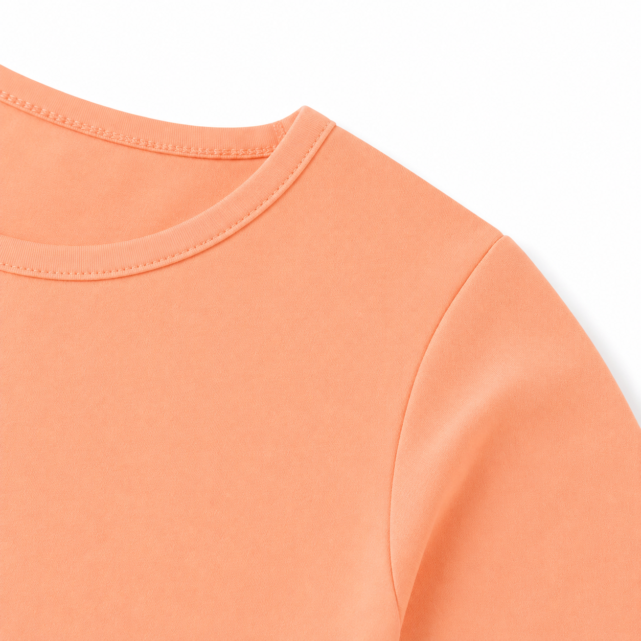 Close-up of the shoulder seam and cotton fabric on the peach kids tee.