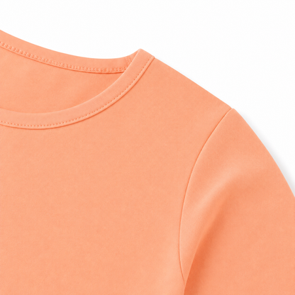 Close-up of the shoulder seam and cotton fabric on the peach kids tee.