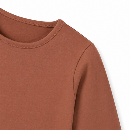 Close-up of the sleeve and cuff on the terracotta cotton long sleeve shirt for kids.