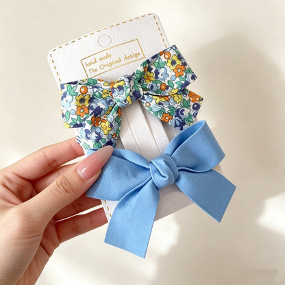 Petal Bloom Bow Clip Set with blue floral bow and light blue bow hair clips.