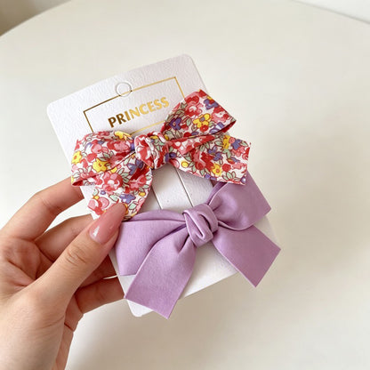 Petal Bloom Bow Clip Set with red floral bow and lavender bow hair clips.
