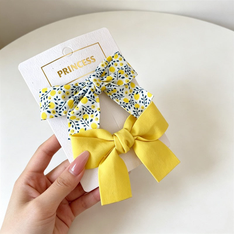 Petal Bloom Bow Clip Set with yellow floral bow and solid yellow bow clips.