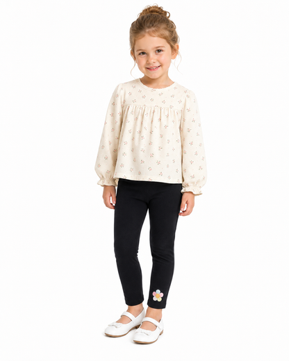 Girl model wearing the black cotton leggings with a small flower detail near the ankle.