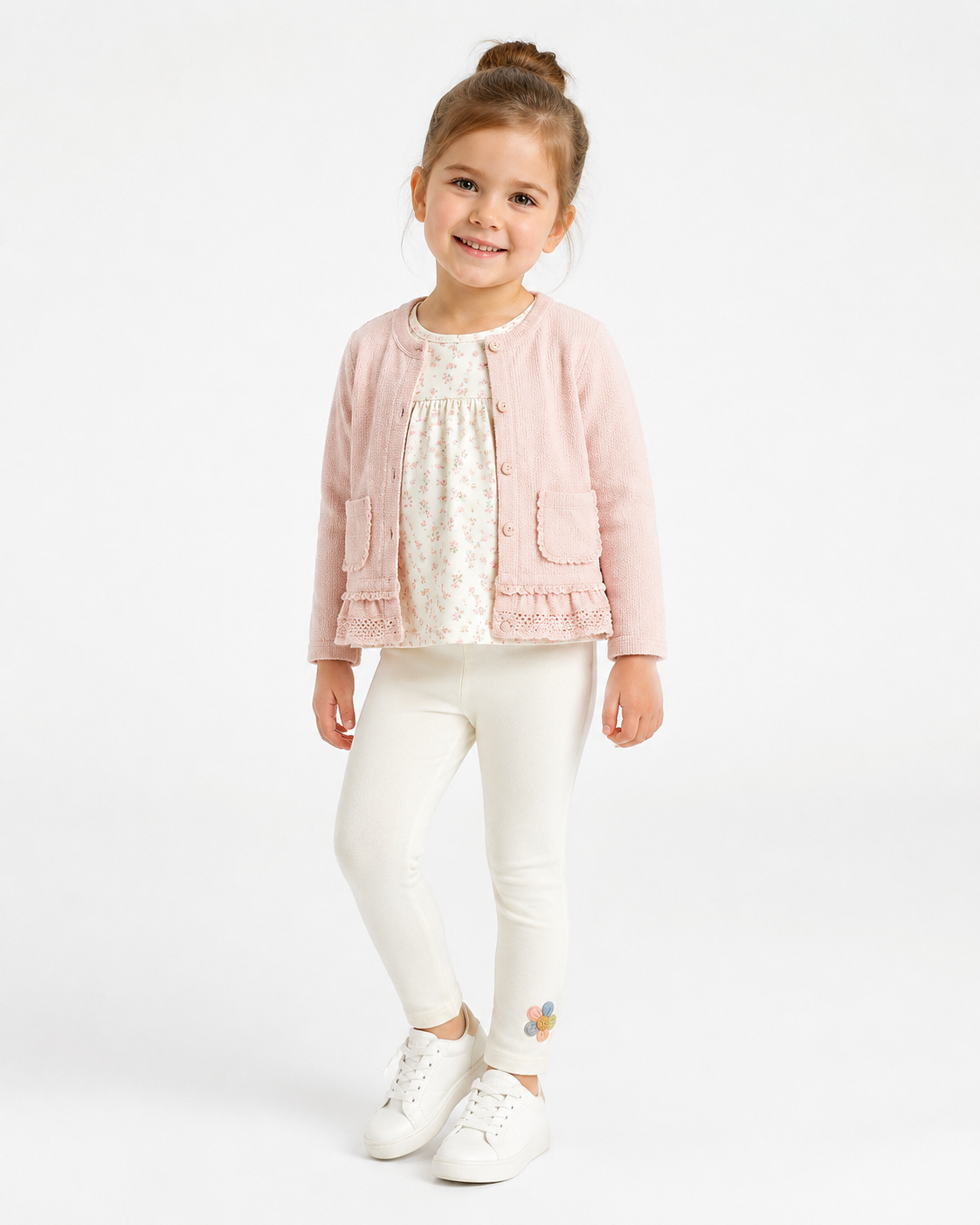 Girl model wearing the ivory cotton leggings with a small flower detail near the ankle.