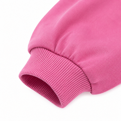 Close-up of the ribbed cuff and fabric detail on the bright pink sweatshirt.