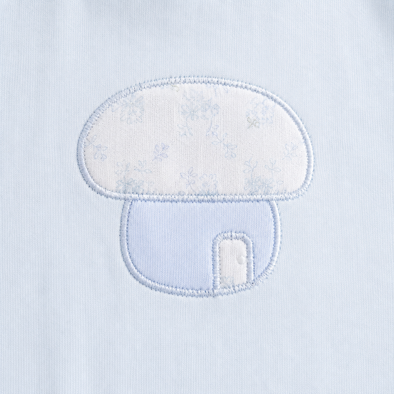 Close-up of the mushroom embroidery on the Powder Blue girls cotton long sleeve top.