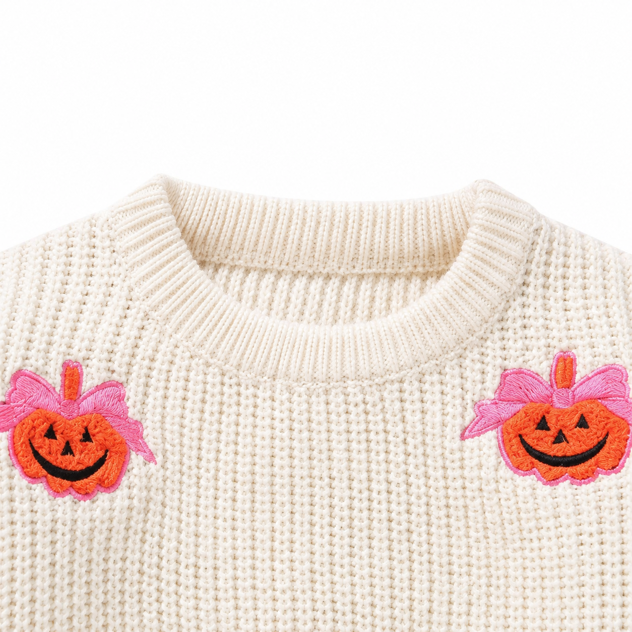 Close up of pumpkin embroidery detail on girls sweater