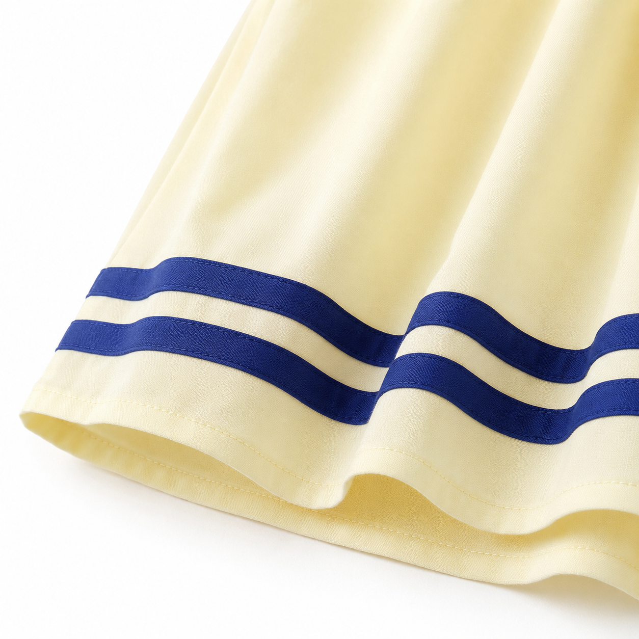 Close-up of the tiered hem and double navy stripe trim on the cotton sailor dress.