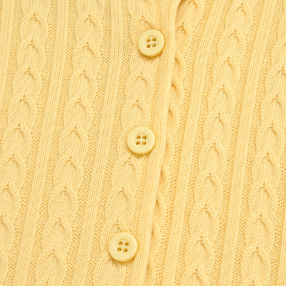 Close-up of the cable-knit pattern and front buttons on the Butter Yellow cardigan.