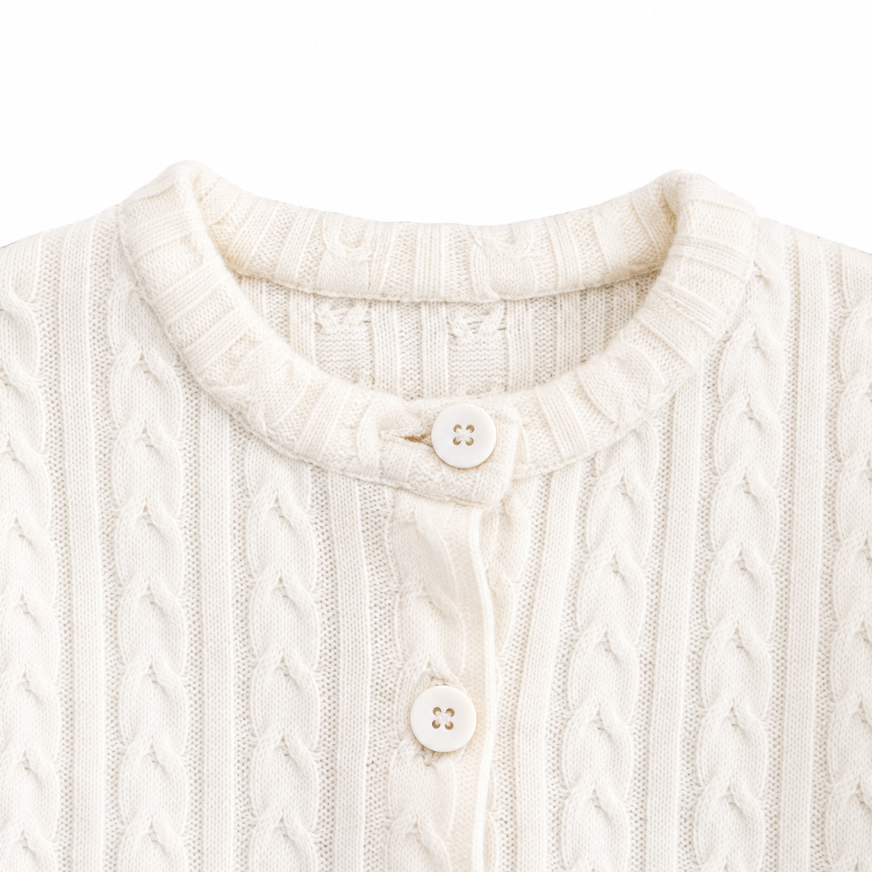 Close-up of the round neckline and button closure on the Ivory cardigan.