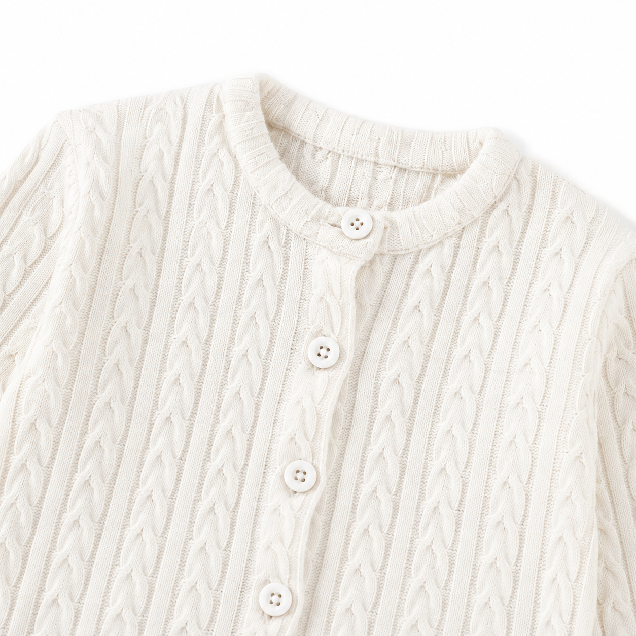 Close-up of the cable-knit pattern and front buttons on the Ivory cardigan.