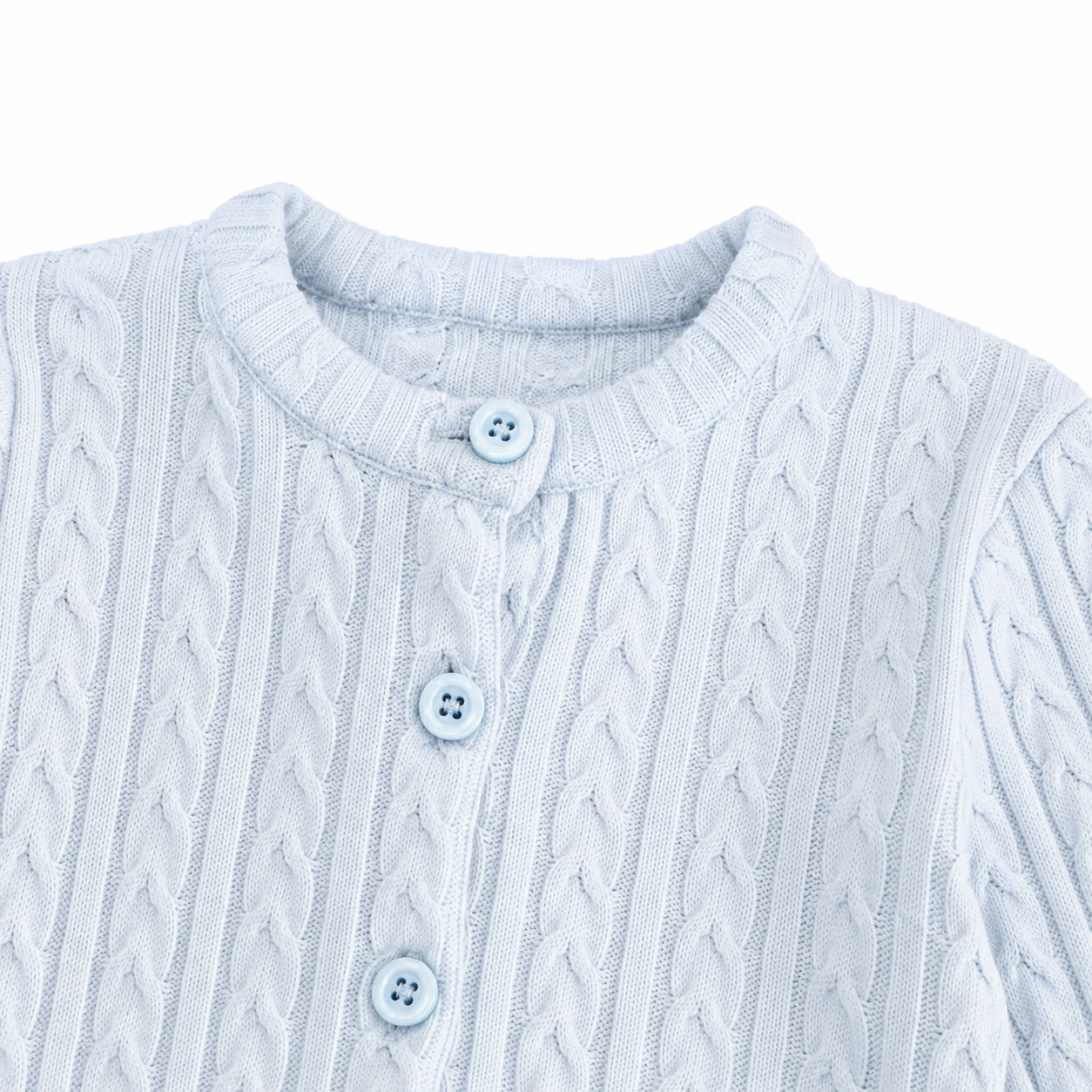 Close-up of the cable-knit pattern and front buttons on the light blue cardigan.