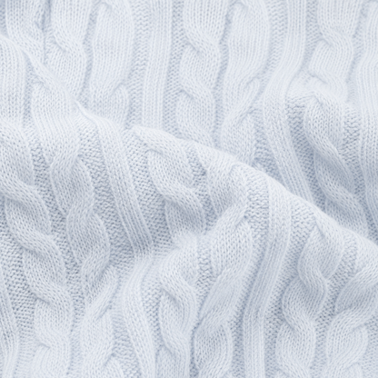 Close-up of the cable-knit cotton texture on the light blue cardigan.
