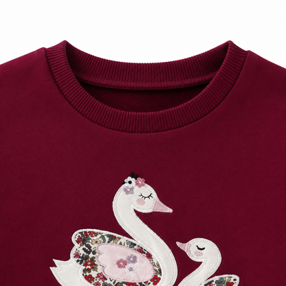 Close-up of the crew neckline and upper bodice of the burgundy girls sweatshirt.