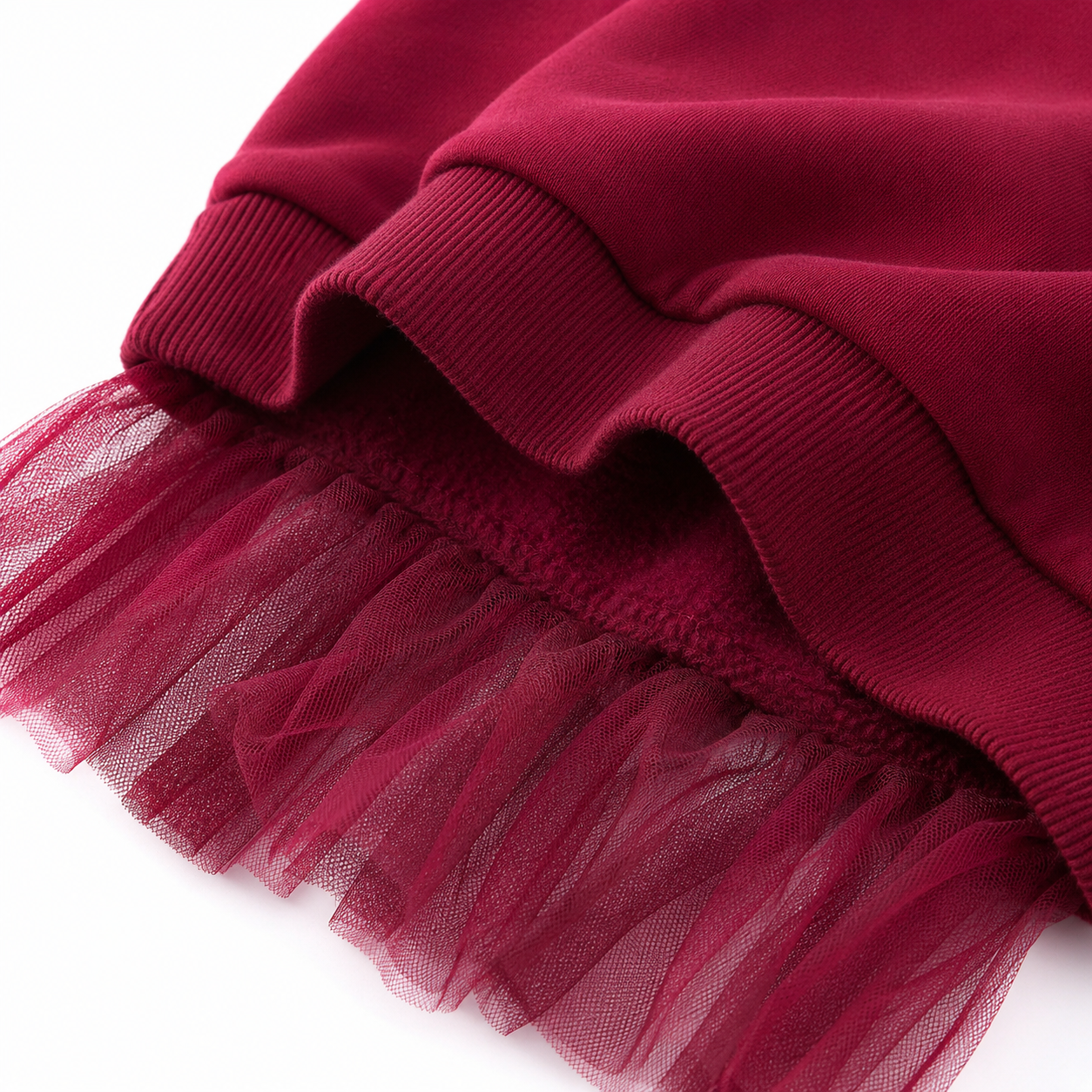 Close-up of the ribbed hem and burgundy tulle overlay detail.